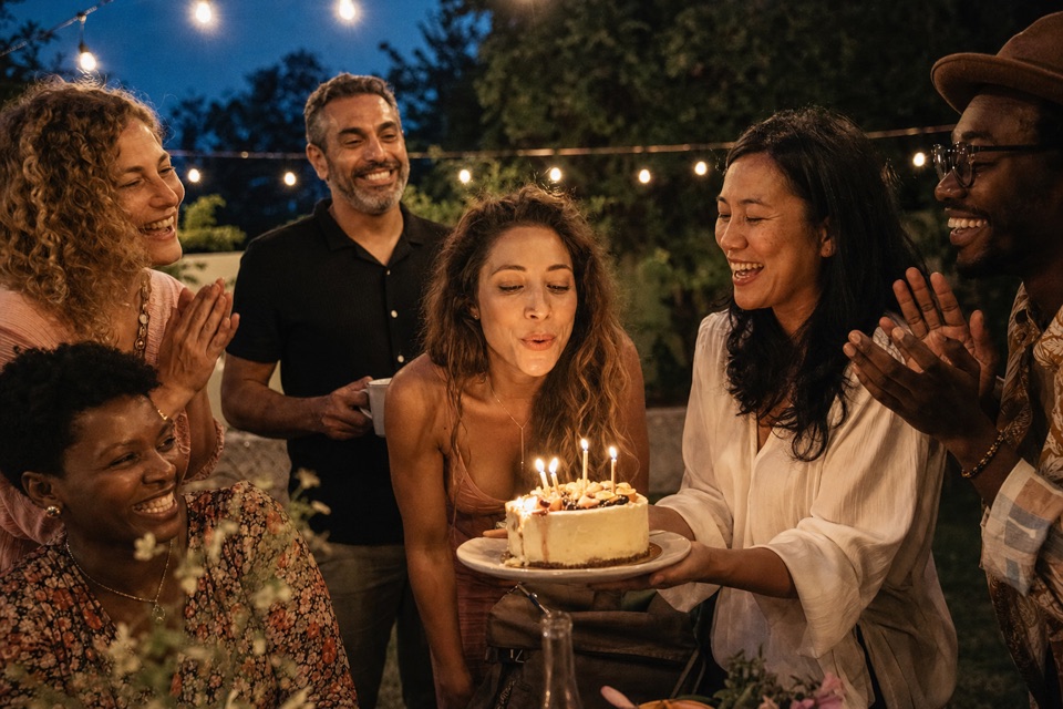 Friends gathered around a celebration cake